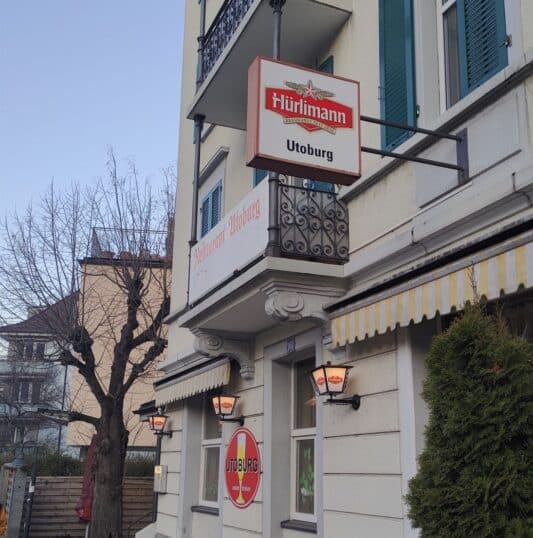 Namenstafel Restaurant Utoburg mit Eingang bei Tag