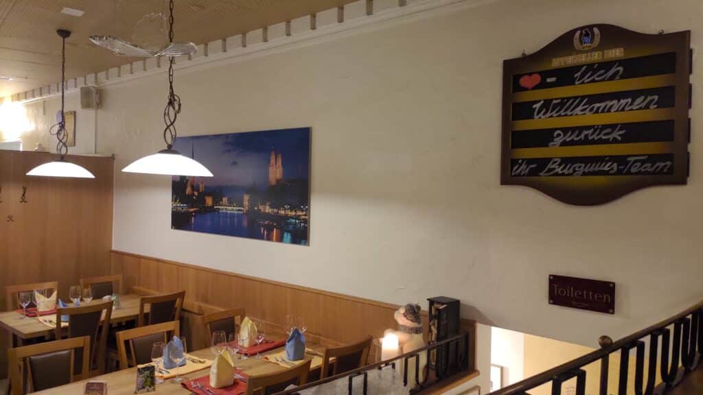 Die rechte Seite des Speisesaals trumpft mit einem Willkommensschild und schöner Aufnahme des nächtlichen Zürich