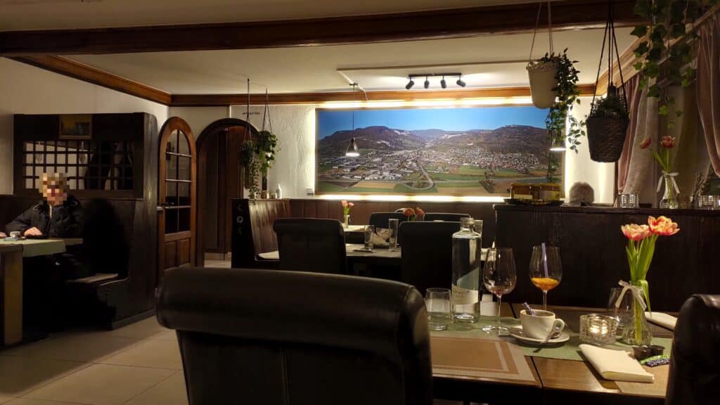 Der hintere Teil des Speisesaals inklusive grossem Wandbild einer Luftaufnahme von Oensingen